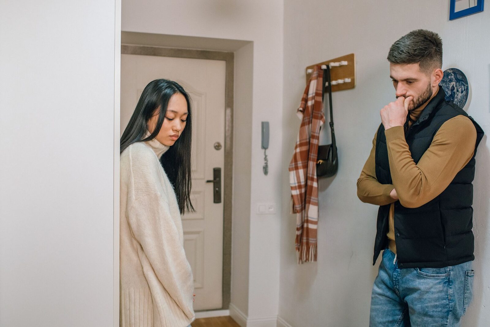 An interracial couple experiencing a tense moment inside their home.